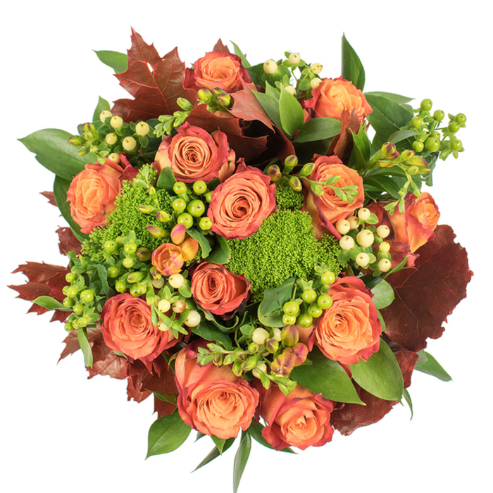 Captured from above on a stark white background, this autumn-inspired floral arrangement is an elegant study in colour, texture and seasonal mood. The central focus is a dense cluster of fully open roses whose petals move from a warm, peachy core to coral and deeper russet tones at the outer layers, producing a subtle bicolour effect like leaves turning at the edge of October. Scattered among the roses are small, round Hypericum berries-some in a lively lime-green hue that introduces bright contrast, others in a creamy, muted yellow that softens and balances the composition. Textural contrast is provided by Green Trick dianthus: small, cushiony green heads that resemble moss or velvet tufts, offering both visual density and an unexpected tactile quality. Complementary elements include broad, shiny green leaves that reflect light and deeper, lobed foliage in burnt red and brown that sits like autumn leaves within the bouquet, lending an earthy, grounding presence. The arrangement's circular, tightly gathered form makes it well-suited as a central tablepiece, casting gentle shadows and catching ambient light to reveal layers of depth. The scent is quietly floral with green undertones, evoking a garden after rain. Perfect for seasonal home decoration, a Thanksgiving centrepiece, or a sympathetic gift, this bouquet channels the harvest palette and comforting textures of fall. Thoughtfully assembled by an experienced florist, it calls to mind the natural colours seen in local walks beside Barking Riverside and the quieter lanes around Creekmouth.